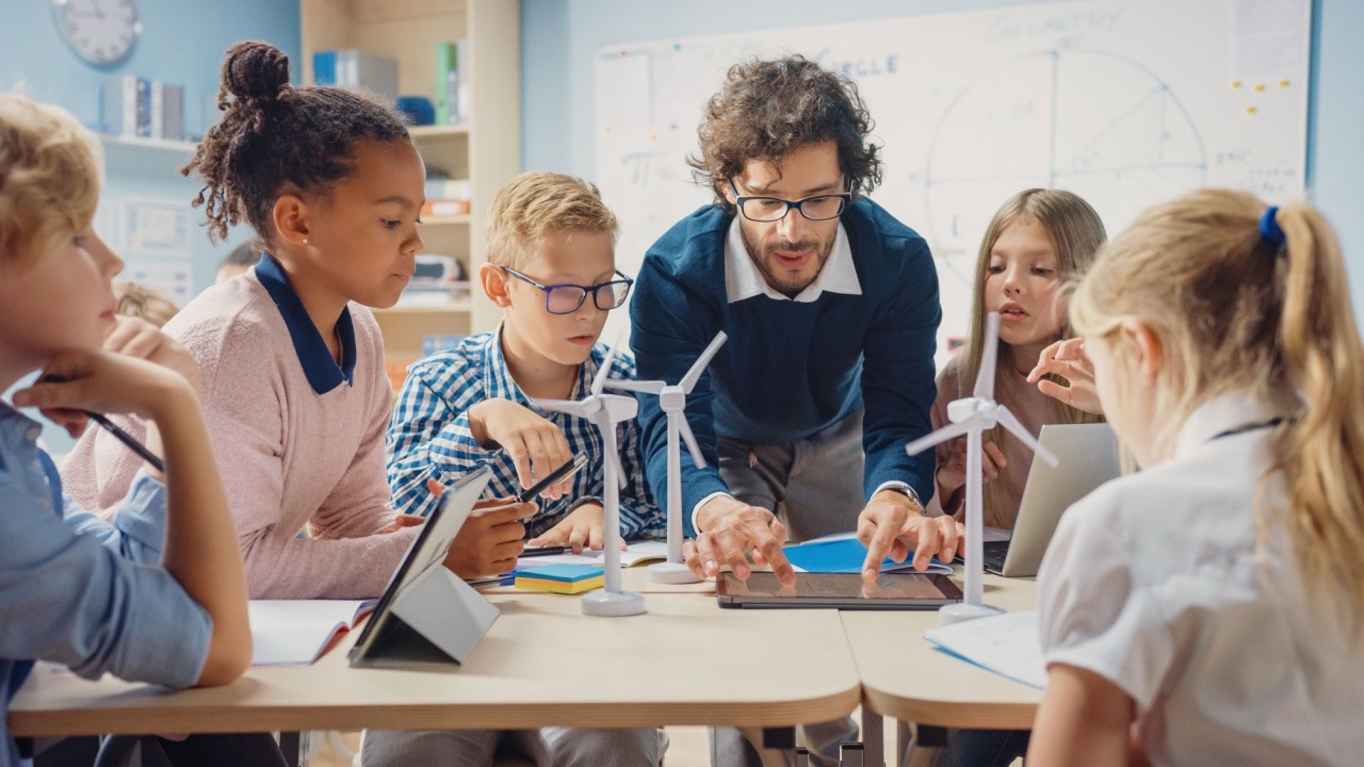 Teacher working with students on wind turbine STEM project.