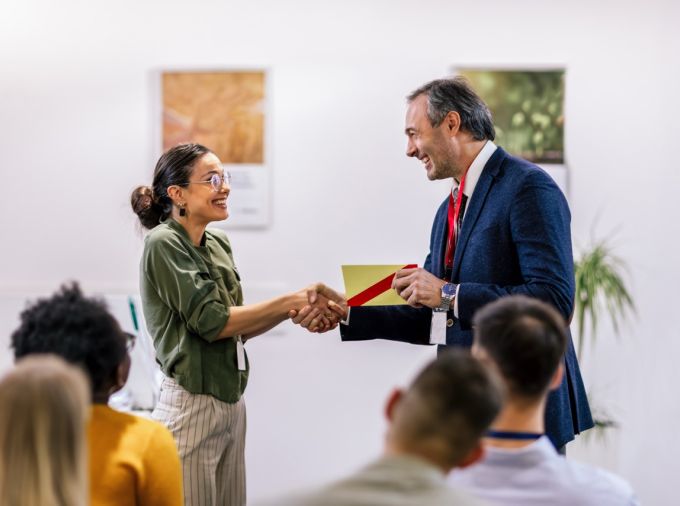 Person receiving an award, shaking hands.