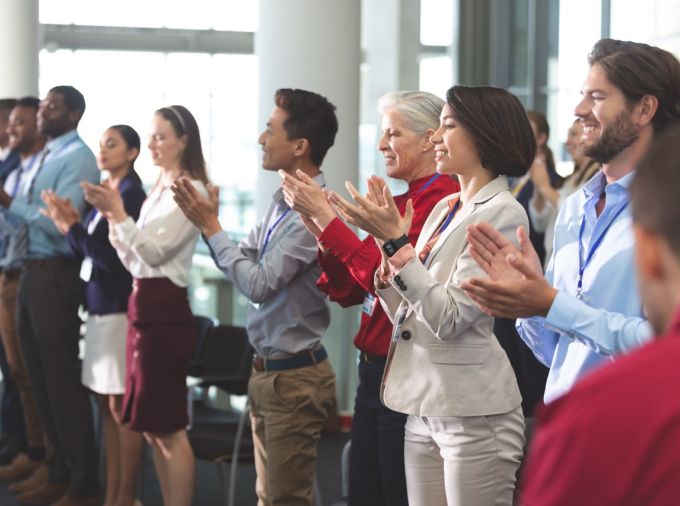 Crowd of professionals clapping for award winners.